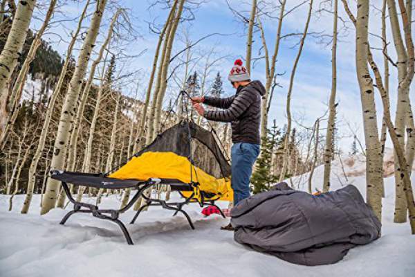 TETON Sports Outfitter XXL Camping Cot used together with a tent in snow conditions.