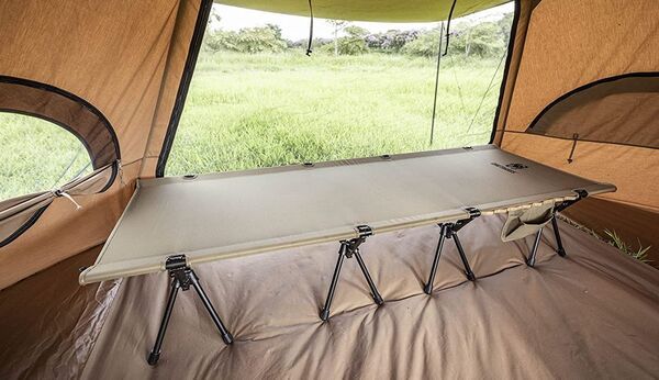 The cot in a tent with extensions.